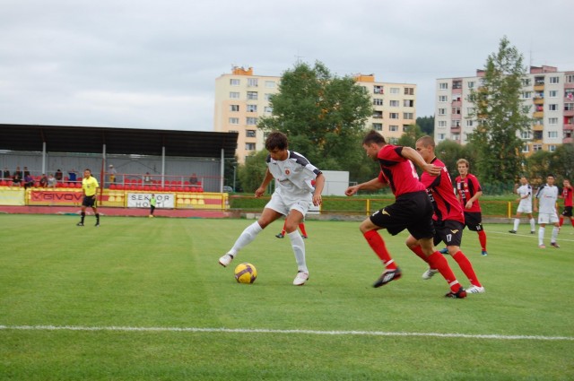 Tomáša Sedláka v drese rezervy Ružomberka (s loptou) stíhajú domáci hráči Milan Bezák a Vladimír Šlosár. 